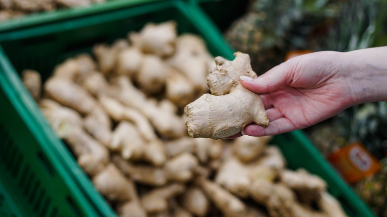 hand grabbing ginger at store