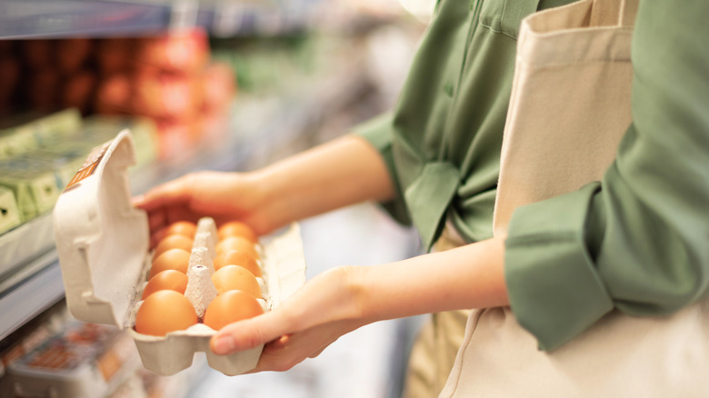 worker holding carton of eggs