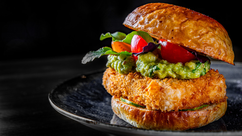 Fried breaded tofu sandwich on dark plate