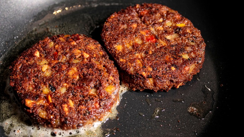 veggie burgers cooking in a pan