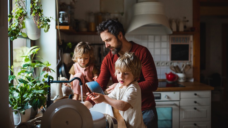 Parent and children cleaning kitchen