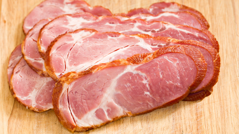 Slices of cottage bacon on wood board