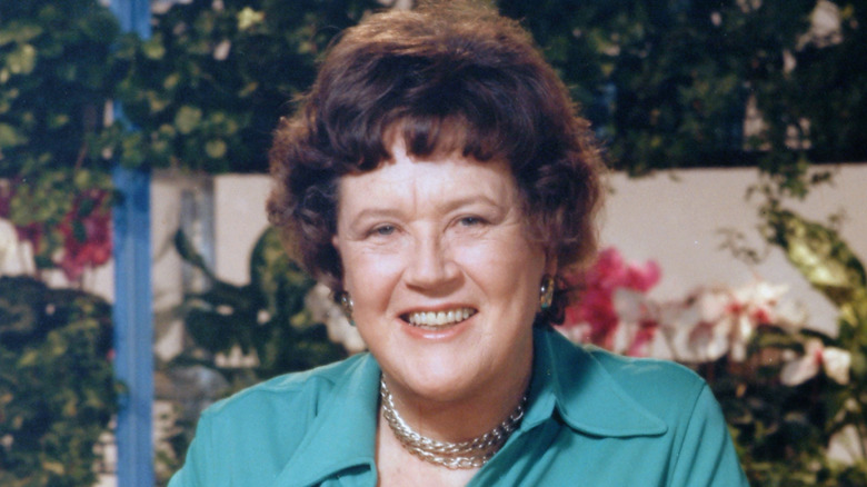 Julia Child smiling with a garden in the background