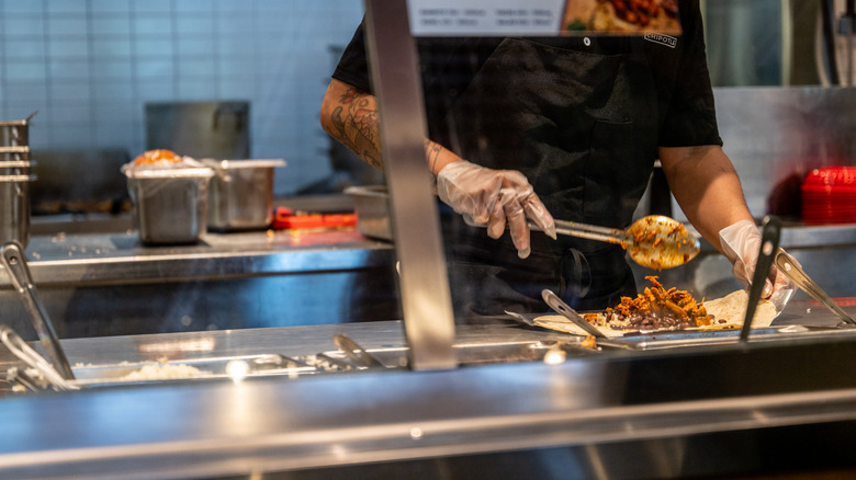 Chipotle employee scooping meat