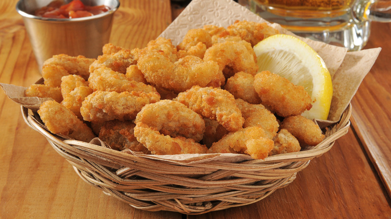 Basket of popcorn shrimp with lemon wedge