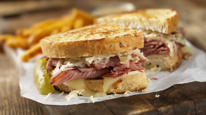 Reuben sandwich with pickle and fries