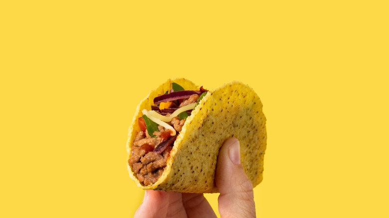 Hard shell taco held in the air
