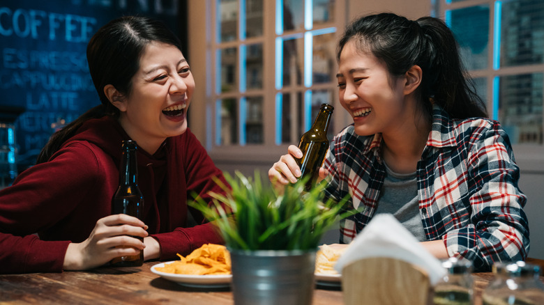 two women drinking beer at bar