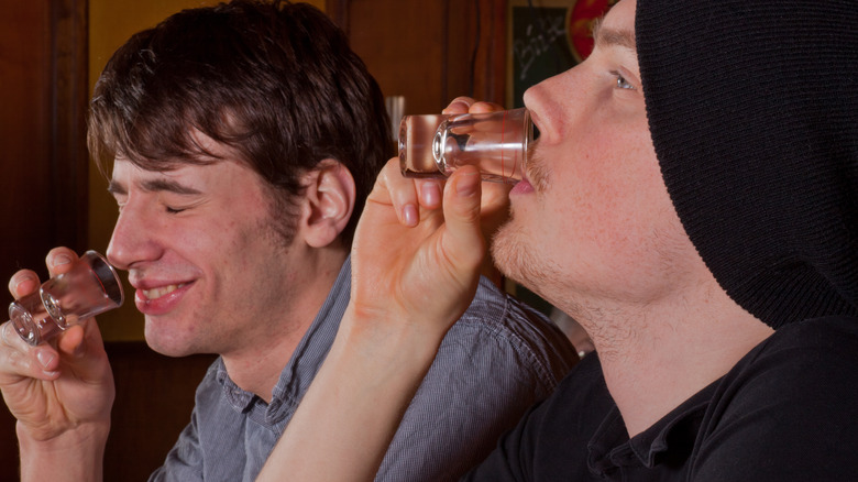 two drunk guys drinking shots