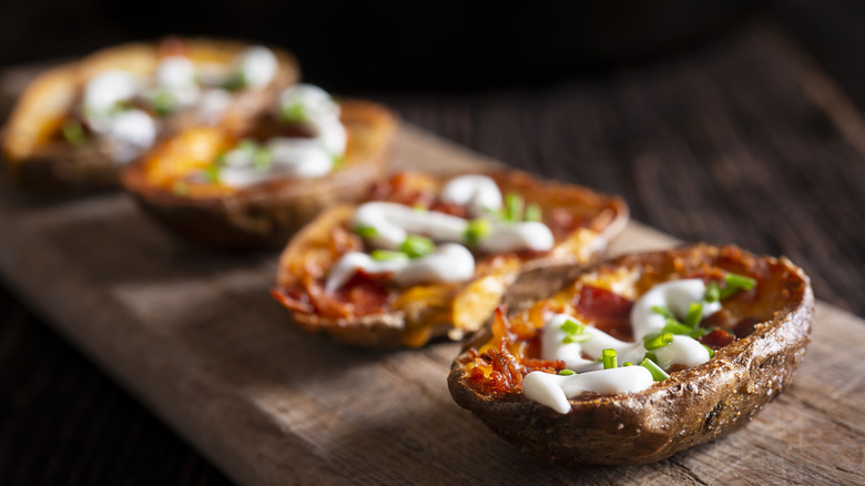 Fried potato skins lined up on a board