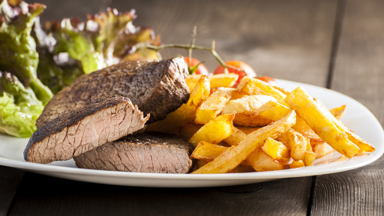 Well-done steak and fries on a plate