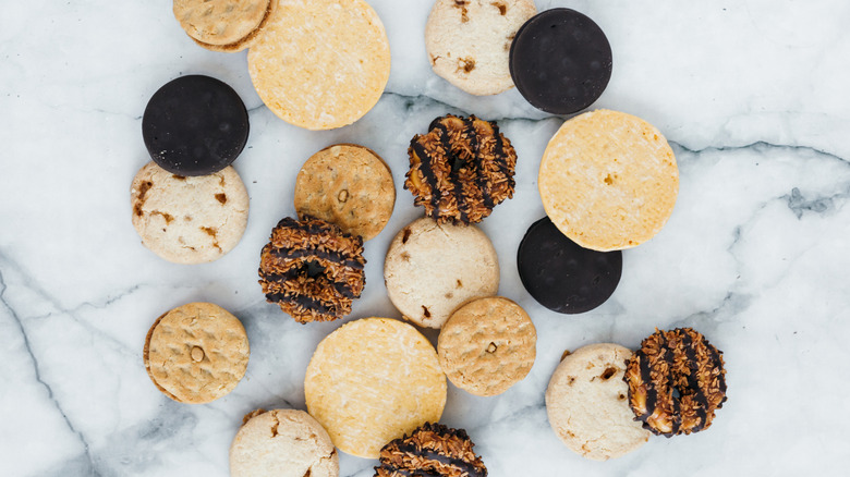 a variety of Girl Scout cookies on a white marble background