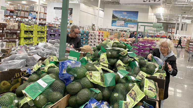 Costco shoppers looking at avocados
