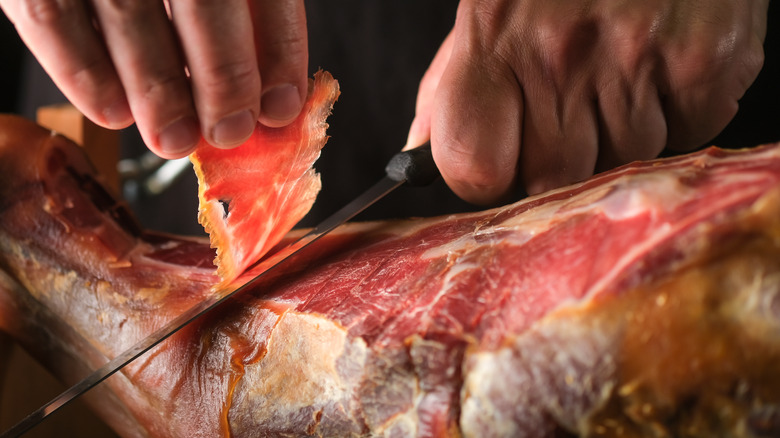 jamón being sliced off the leg