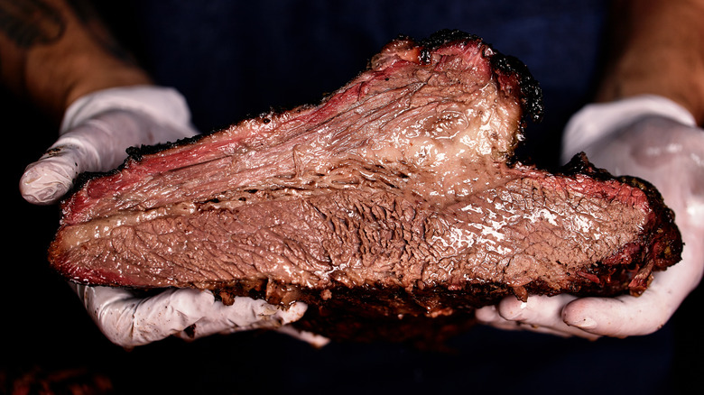 Hands holding brisket