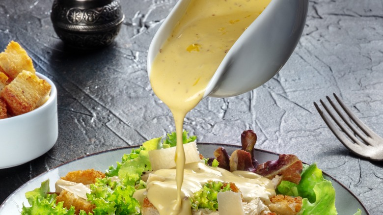dressing pouring onto salad