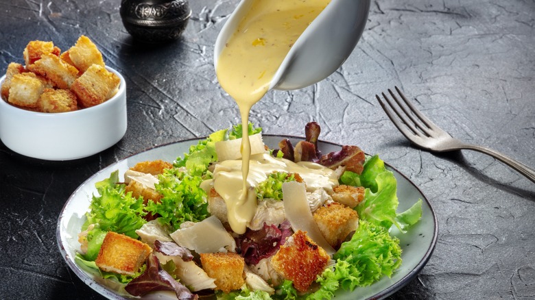 Caesar dressing being poured 
