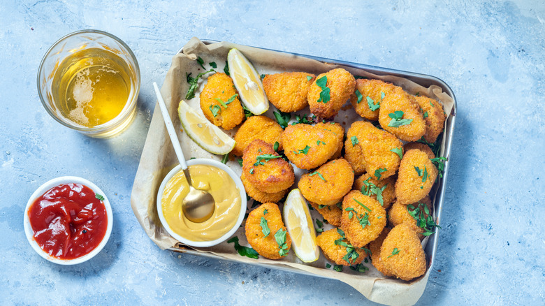 chicken nuggets on a tray with condiments and drink