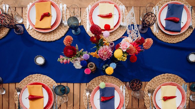 Overhead shot of set table with different colored napkins and mismatched glassware