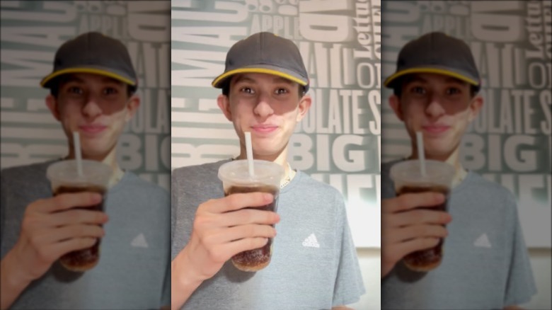 a tiktok employee holding a mcdonalds soda