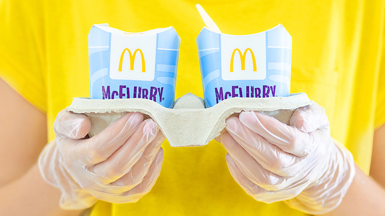 Close-up on gloved hands holding to-go McFlurries