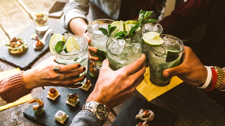 Five people cheer their cocktails