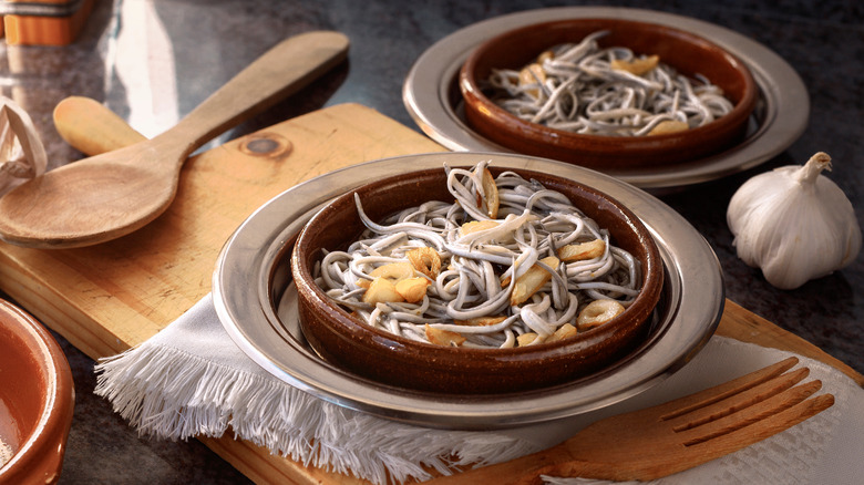 Two dishes of angulas with wooden cutlery