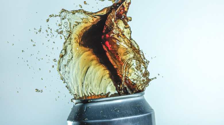 can of soda with the contents bursting up from the top