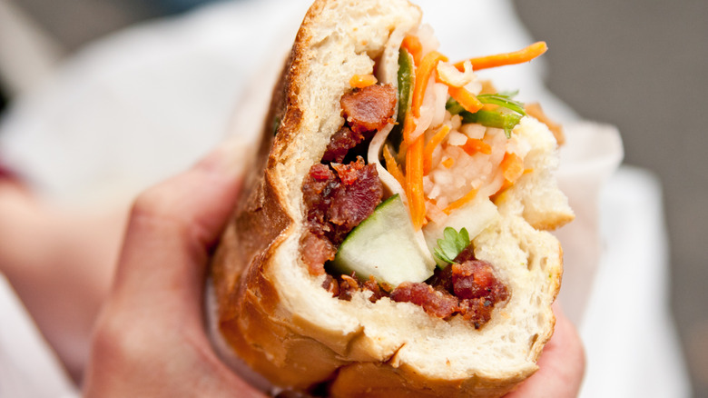 Hand holding banh mi sandwich