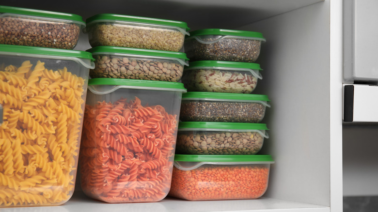 Plastic containers storing dried goods in cupboard