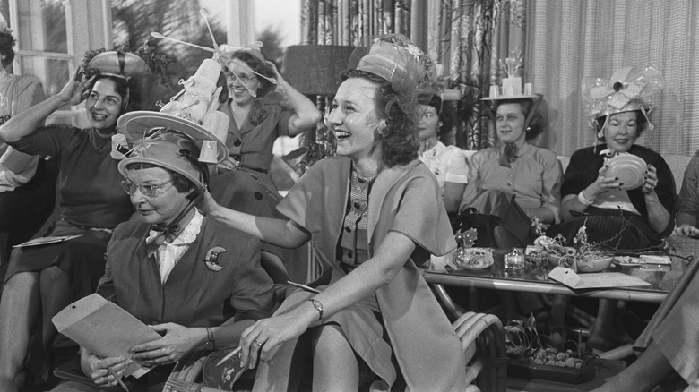 Women wear Tupperware hats at living room party