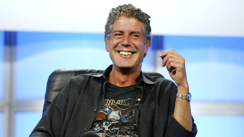 Anthony Bourdain smiling and wearing a black shirt.