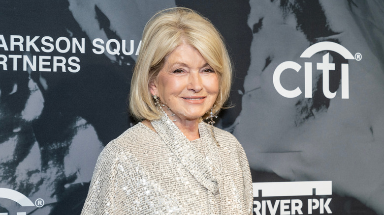 Martha Stewart in a shimmery silver blouse on a red carpet.