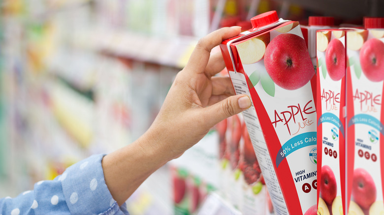 hand grabbing box of apple juice in store