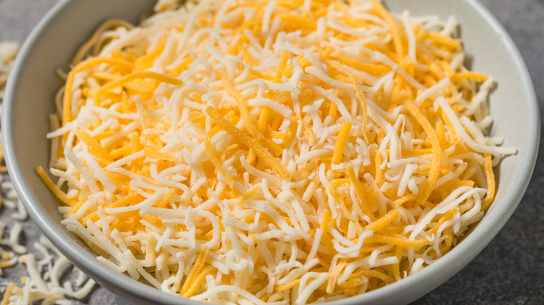 A bowl of yellow and white shredded cheeses