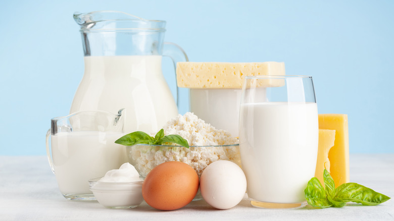 pitcher of milk, brown and white egg, cheese, flour, and other ingredients on white background
