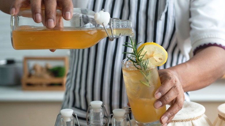 Man pouring kombucha into glass