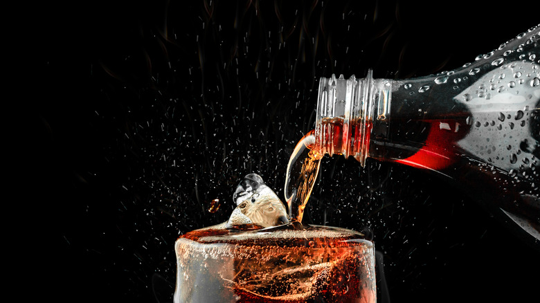 Pouring carbonated drink into glass