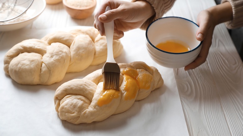 brushing egg wash on bread