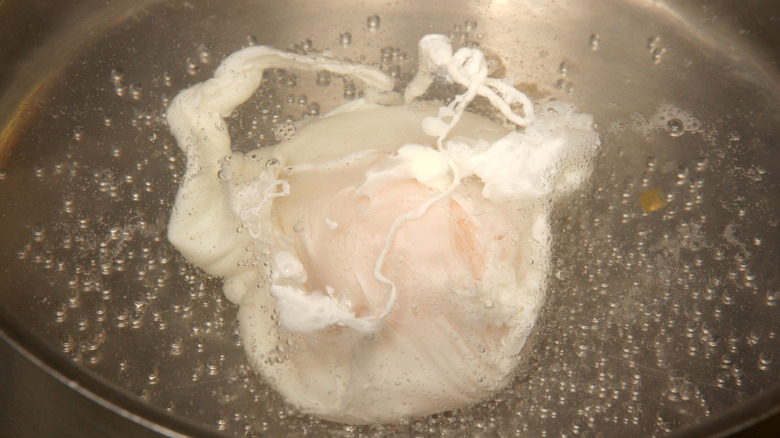 A simmering poached egg