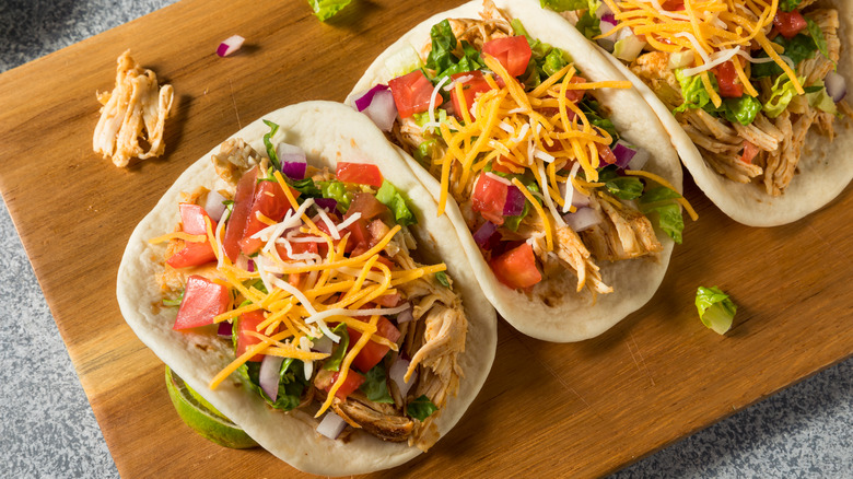 Shredded chicken tacos on board