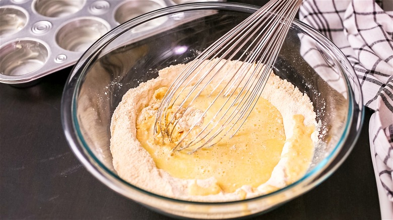 whisking cornbread mix in bowl