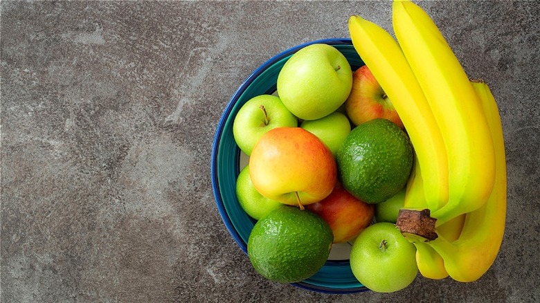 Bowl of apples, bananas, and avocados