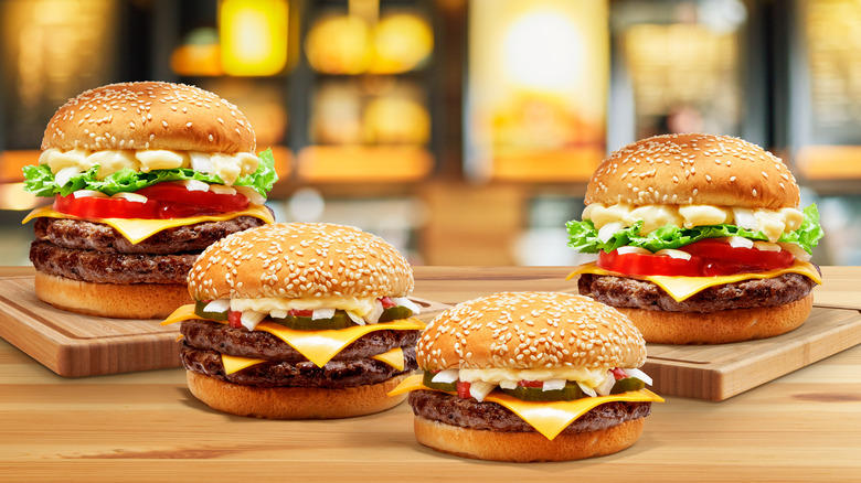 four burgers on wood display