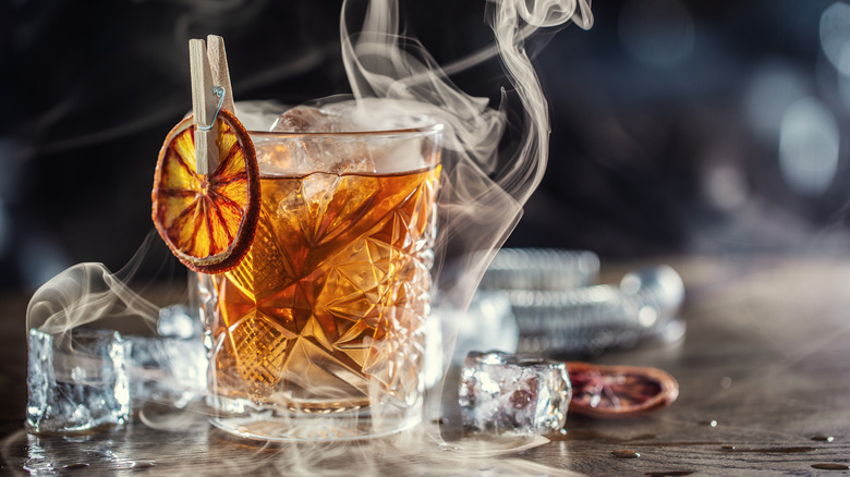 Old Fashioned cocktail with an orange slice pinned to the side.