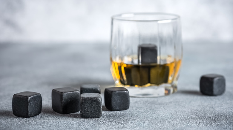 Whiskey stones in front of glass of whiskey