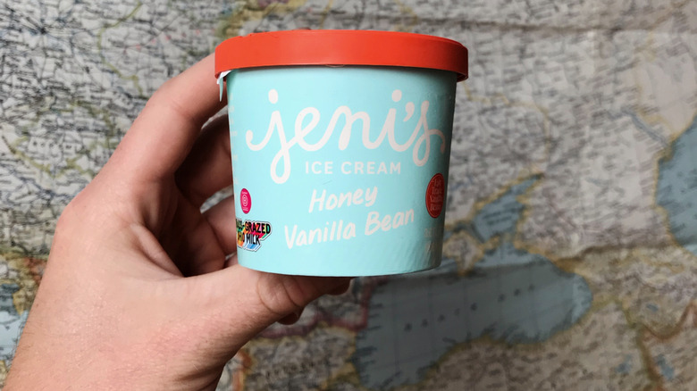 Hand holding Jeni's vanilla ice cream in front of map