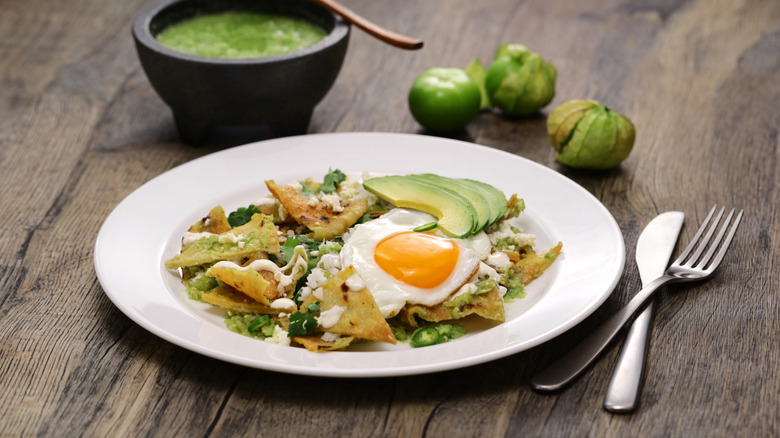 Chilaquiles topped with salsa verde, a fried egg, and avocado