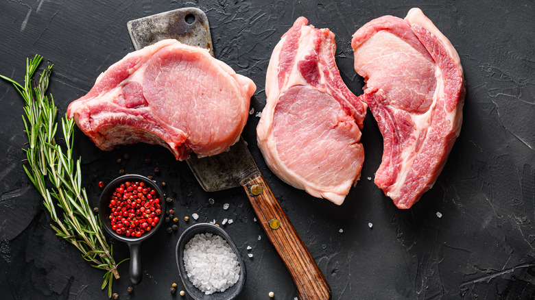 pork chops on black slate with herbs