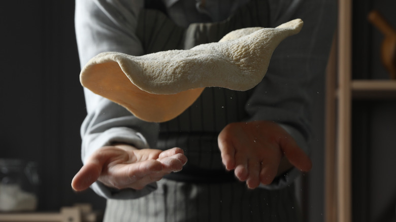 Close-up of pizza dough being tossed
